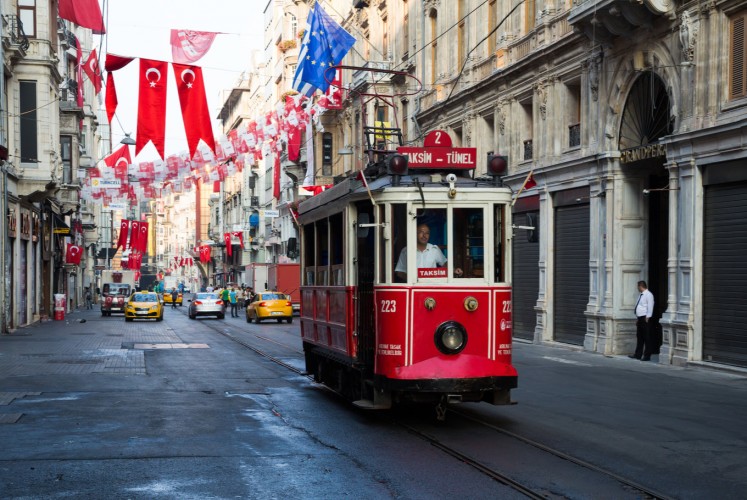 A classic tram passes through Istanbul’s popular Taksim Square.
