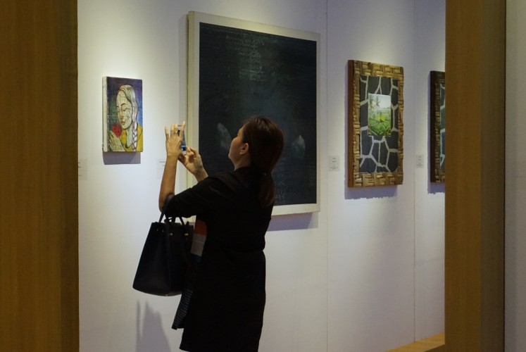 A visitor marvels at one of the paintings displayed at the 