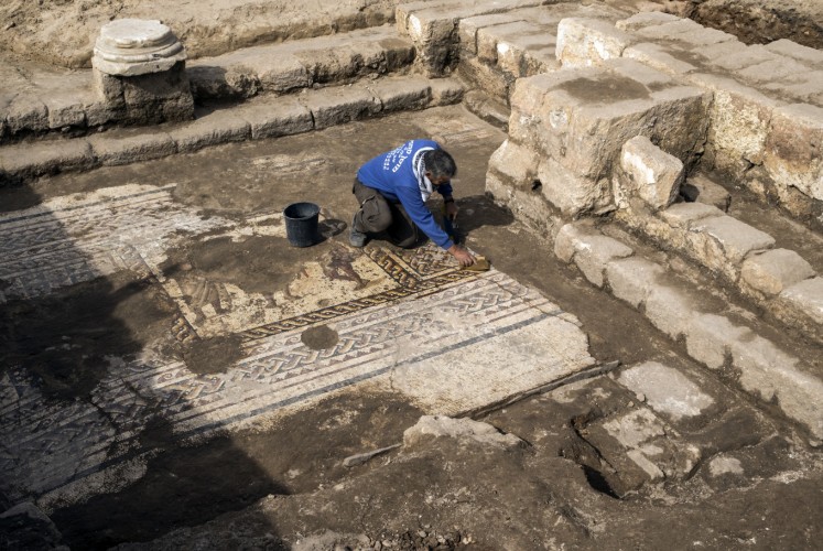 Workers from the Israeli Antiquity Authority (IAA) clean a rare Roman mosaic from the 2nd–3rd centuries at the Israeli Caesarea National Park on February 8, 2018. According to Dr. Peter Gendelman and Dr. Uzi ‘Ad, directors of the excavation for the IAA: 'This colourful mosaic, measuring more than 3.5 x 8 meters, is of a rare high quality. It features three figures, multicoloured geometric patterns and a long inscription in Greek.'