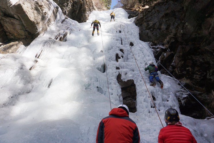 Climbers scale an ice cliff.