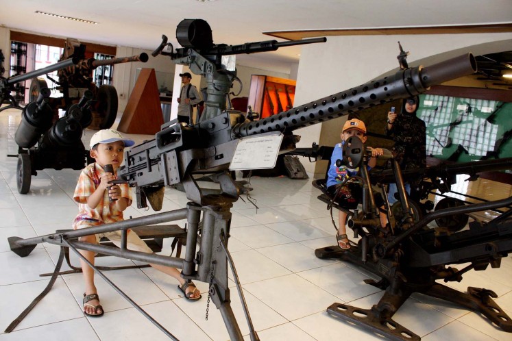 Two kids play with old heavy machine guns once used by the Indonesian Military (TNI) at the Satria Mandala military museum in Jakarta on Sunday. As apart of the celebration of TNI.