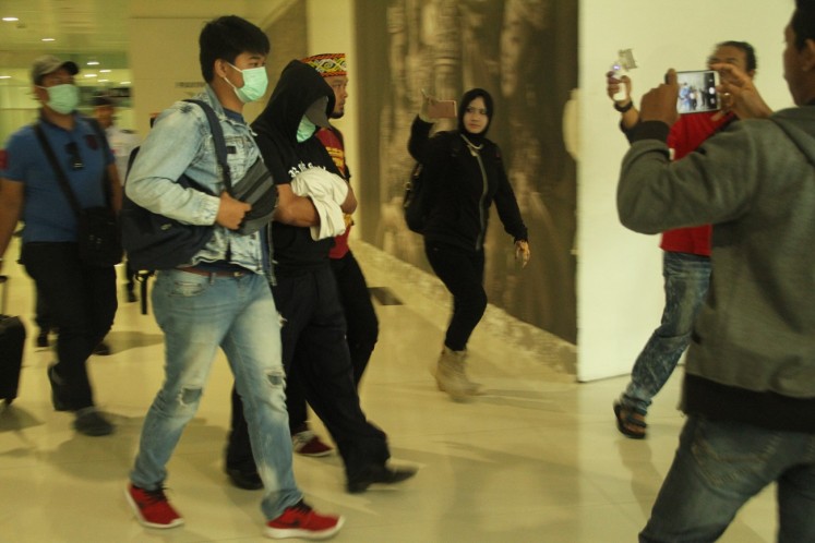 Fighting against drugs: East Kalimantan Police officers escort AR (center with black shirt), 48, who was arrested over alleged drugs possession at Sepinggan Airport in Balikpapan, East Kalimantan, on Thursday.