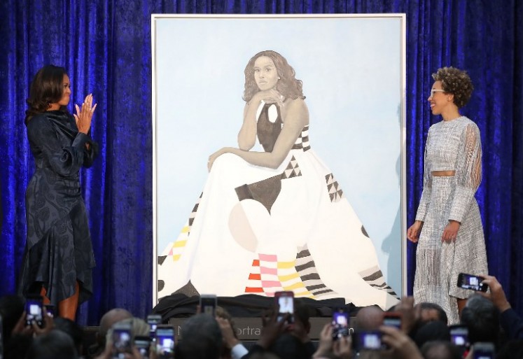 WASHINGTON, DC - FEBRUARY 12: Former U.S. first lady Michelle Obama (L) and artist Amy Sherald unveil her portrait during a ceremony at the Smithsonian's National Portrait Gallery, on February 12, 2018 in Washington, DC. The portraits were commissioned by the Gallery, for Kehinde Wiley to create President Obama's portrait, and Amy Sherald that of Michelle Obama. 