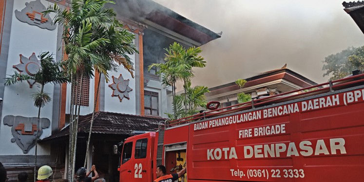 Damaged: Black smoke emanates from a building at the Bali governor's office complex on Feb. 13 as a fire truck attempts to extinguish the fire.