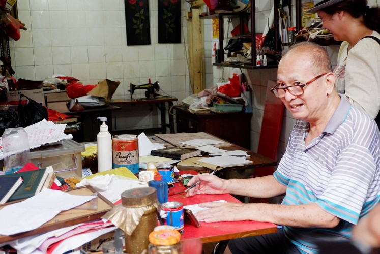 Man of art: Calligraphy artist Akwet works at his studio in Glodok.