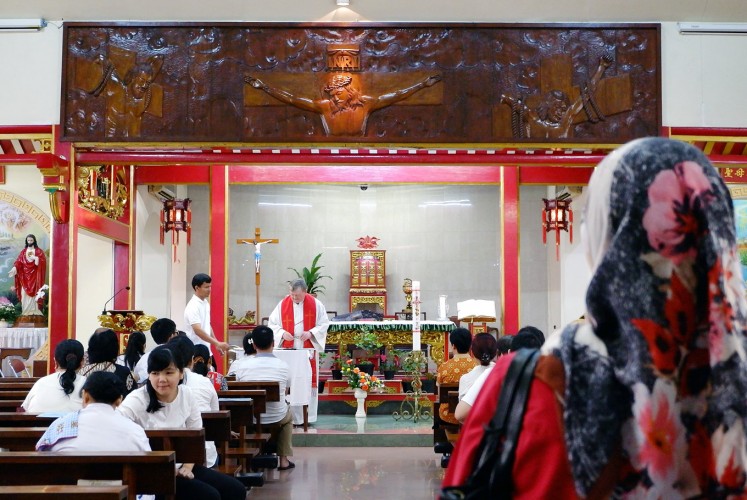 Chinese style: A Muslim woman looks inside Santa Maria de Fatima Church in Glodok.