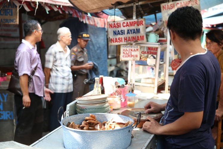 It’s hot: People wait to buy sekba (pork soup), also known as bektim, in the popular Gang Gloria in Glodok, West Jakarta.