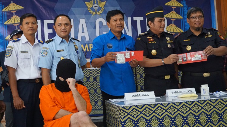 Drug presser: Customs and Excise Office personnel at Ngurah Rai International Airport show evidence allegedly confiscated from Siegfried Karl Achim Ruckel in a press conference on Feb. 22.

