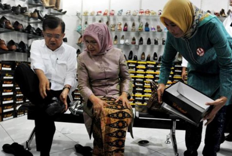 Vice President Jusuf Kalla, accompanied by his wife, Mufidah Jusuf Kalla, tries on shoes at a shoe store in Cibaduyut Market in Bandung, West Java.