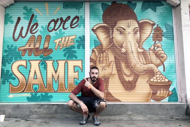 Message of peace: Portuguese street artist Mr Dheo poses before his freshly completed work in Canggu.