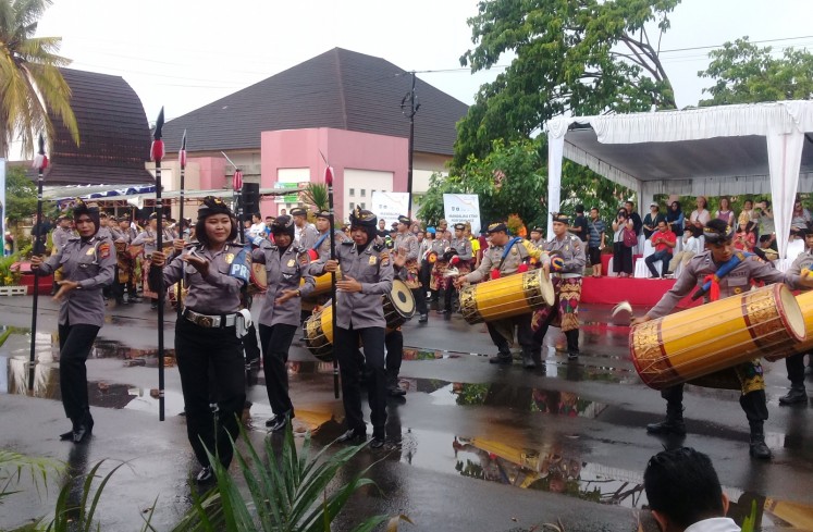 Members of the Central Lombok precinct police join the parade by playing 