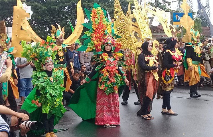 Participants of the parade walk down the street in Central Lombok.