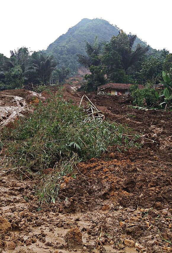 Buried: The mudslide engulfed four houses in Kampung Bonjot.