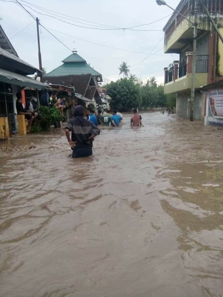 Inundated: Local residents pass through a flooded road in their village in Dompu regency, West Nusa Tenggara, on March 5.