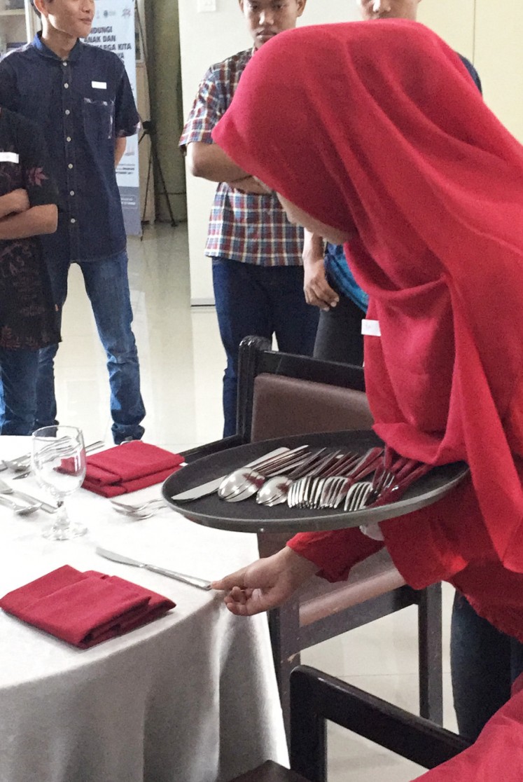 A program participant learns to set a table.