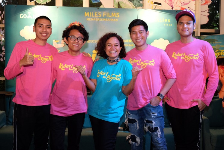 Director Riri Riza and producer Mira Lesmana (center) pose alongside members of pop-jazz trio RAN - Rayi (left), Nino (second right) and Asta (right) - during the press conference for 'Kulari ke Pantai' (I Run to the Beach) on March 7 in Kemang, South Jakarta.