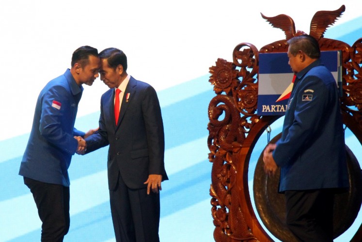 President Jokowi (center) shakes hands with Democratic Party executive Agus Harimurti Yudhoyono (left), witnessed by party chairman Susilo Bambang Yudhoyono, during the opening of the party's 2018 national leaders meeting at Sentul International Convention Center (SICC) in Bogor, West Java, on March 10. 