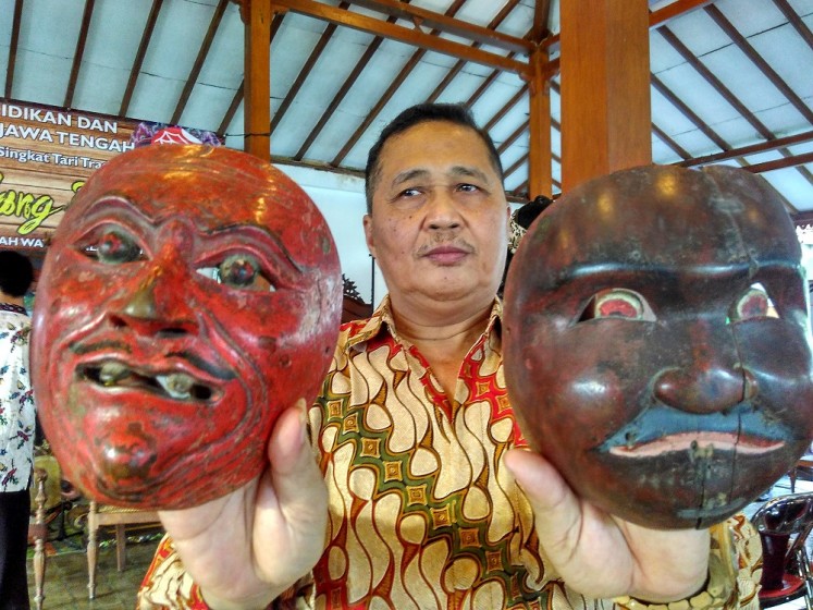 Bambang Suwarno shows two masks typically worn by 'topeng dalang' dancers.