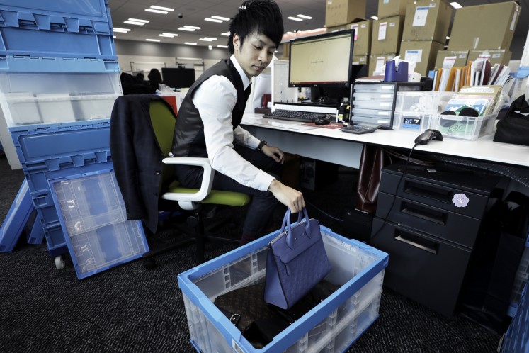 A SOU employee checks a used Louis Vuitton bag at the company office in Tokyo.