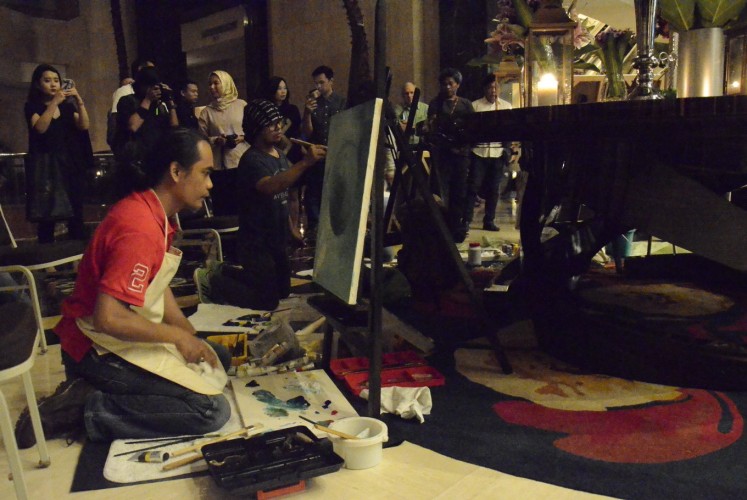 Indonesian artists Iwan Suhaya (left) and Kinkin (second left) paint in public during the Earth ‘ART’ Hour event at The Ritz-Carlton Jakarta in Mega Kuningan, South Jakarta, on Saturday.