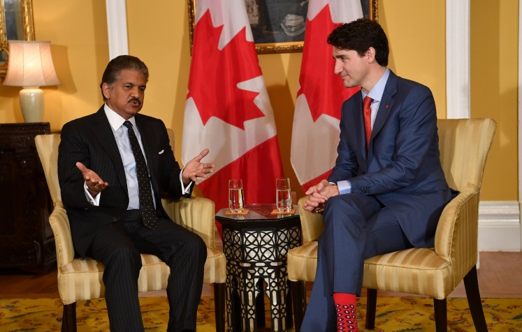 Canada's Prime Minister Justin Trudeau (R) chats with the chairman of Indian multinational conglomerate Mahindra Group, Anand Mahindra (L), during their meeting in Mumbai on February 20, 2018. 