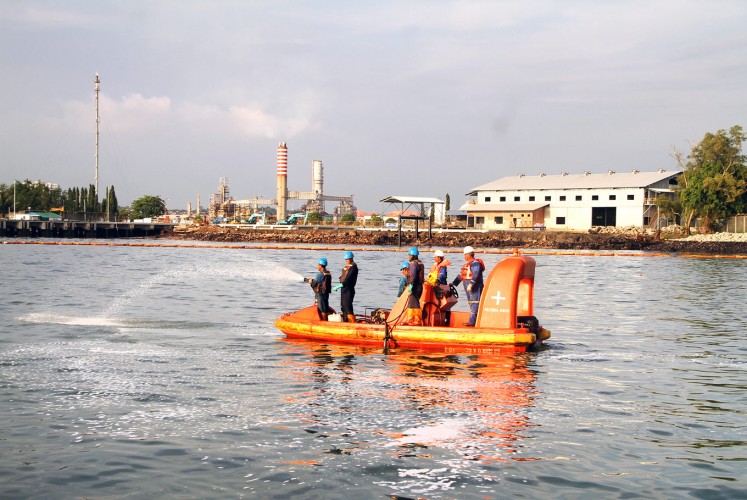 Cleaning up the mess: Officials from state-owned oil and gas company Pertamina spray dispersant fluid to clear an oil spill in Balikpapan Bay, East Kalimantan, last week. The oil reportedly leaked from a broken pipe belonging to Pertamina.