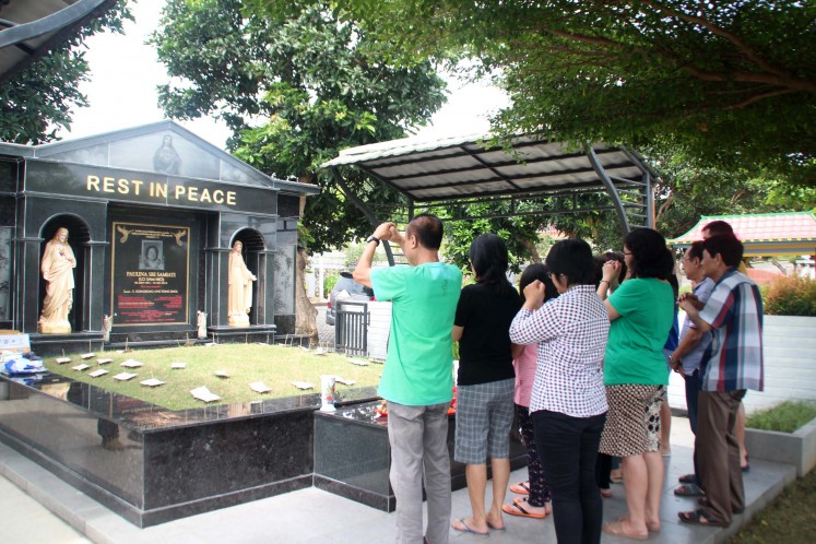 Despite being Catholic, this family maintains Ceng Beng traditions, such as performing rituals at their ancestors' tombs.