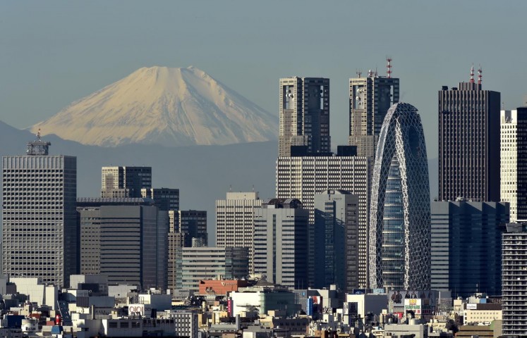 Japan's highest mountain, Mount Fuji at 3,776m, is seen behind skyscrapers in Tokyo's Shinjuku area on November 28, 2015. 