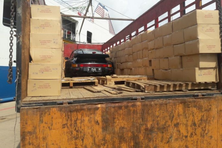 A Porsche Turbo S is hidden on a truck on board of the Fajar Bahari V vessel and is covered with cardboards. 