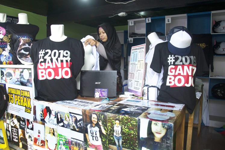 A staff member of a t-shirt shop in Yogyakarta’s Umbulharjo district, where a number of tourist sites are located, waits for customers to buy t-shirts displaying the pun #2019GantiBojo (2019 change your spouse). The t-shirt slogan is a play on #2019GantiPresiden (2019 change the President), which has gone viral on social media ahead of the 2019 presidential election. The T-shirts are sold for Rp 125,000 (US$9.08).