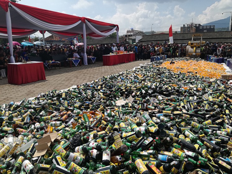 Dangerous substance: Thousands of bottles of 'oplosan' (bootleg liquor) are destroyed at Alun-Alun Cicalengka, Bandung regency, West Java, on April 19. 