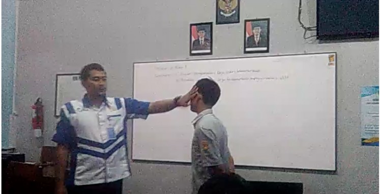 A screenshot of the viral video showing a vocational school teacher slapping his student in Purwokerto, Banyumas, Central Java.  