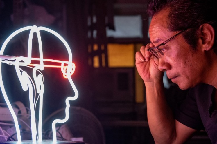 In this picture taken on April 16, 2018, neon sign maker Wu Chi-kai looks at one of his works.