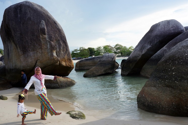 Visitors pose for a photograph while strolling along Tanjong Tinggi Beach on Belitung Island in Bangka-Belitung Islands province. This beach was one of the shooting locations for Laskar Pelangi.