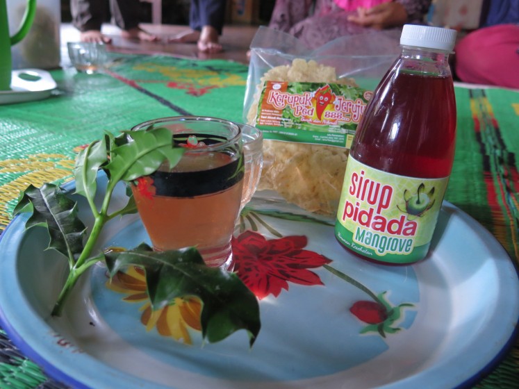 A pack of kerupuk jeruju, a snack made from acanthus leaves, and a bottle of pidada, a syrup made from mangrove apples, are arranged on a plate. After the HKm permit issue in 2017, some 14 Lubuk Kertang women established their own group named Kelompok Tani Abadi Mangrove to produce kerupuk jeruju and pidada syrup. (JP/Moses Ompusunggu)
