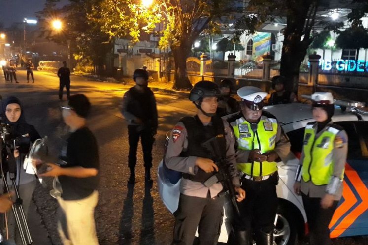 Police officers cordon off a road in front of the Police Mobile Brigade headquarters (Mako Brimob) in Depok, West Java, on Wednesday morning following a riot inside the Mako Brimob detention center.
