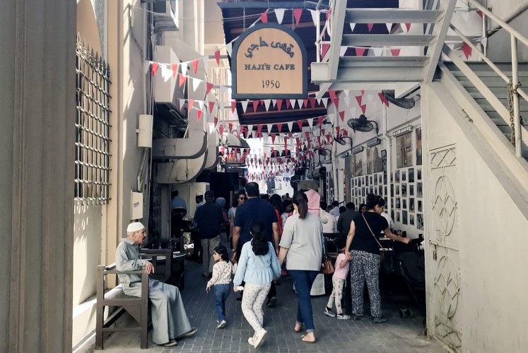 Gather round: Visitors flock to the alleyway in Manama Souq in which Haji Café is located.
