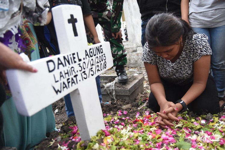 Novi, the sister of Daniel Agung Putra Kusuma, 14, prays at her brother's grave at the Putat Gede cemetary in Surabaya on May 15. Daniel was a victim of a suicide bombing at Surabaya Pentecostal Church (GPPS) on May 13. 