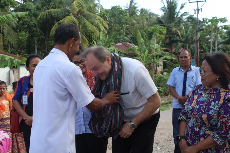 Warm welcome: Hans Farnhammer, the European Union’s head of cooperation in Indonesia (right), gets traditional hand woven fabric from Buraen subdistrict head Jhon Nomeni during a visit to Buraen subdistrict, Kupang, East Nusa Tenggara, on Wednesday.