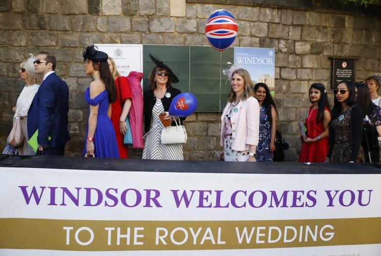 Royal fans gather outside Windsor Castle ahead of the wedding of Britain's Prince Harry and Meghan Markle in Windsor, on May 19, 2018. 