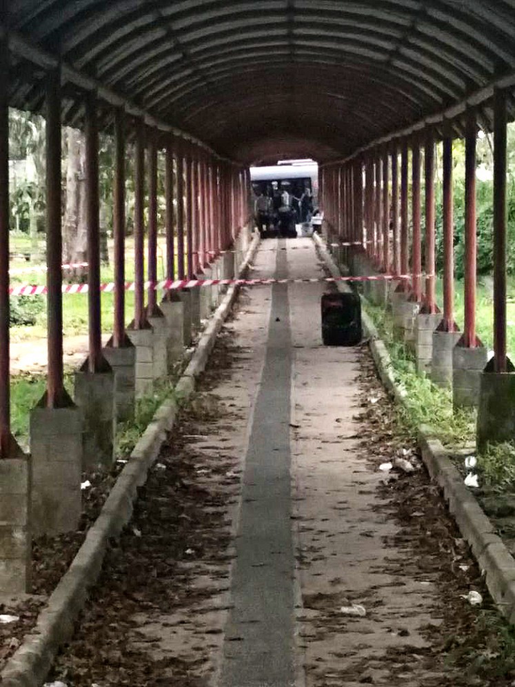 Gegana bomb squad personnel from the Riau Islands Police's Mobile Brigade cordon off the location where a suitcase was left unattended in Batam on Wednesday. 