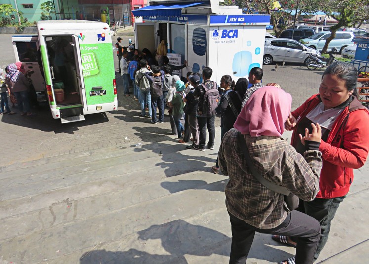 Be patient! People make a long queue to change their money into smaller denominations at a newly launched Bank Indonesia (BI) mobile cash vehicle in Malang, East Java, on May 28. 