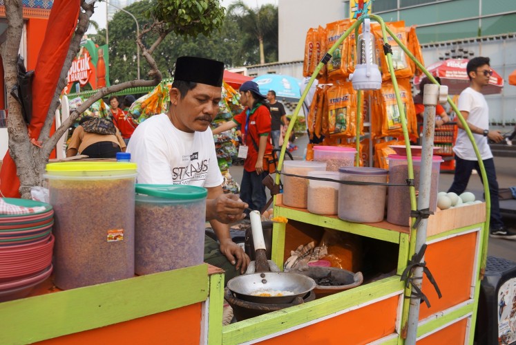 A seller cooks 'kerak telor' at the 2018 Jakarta Fair.