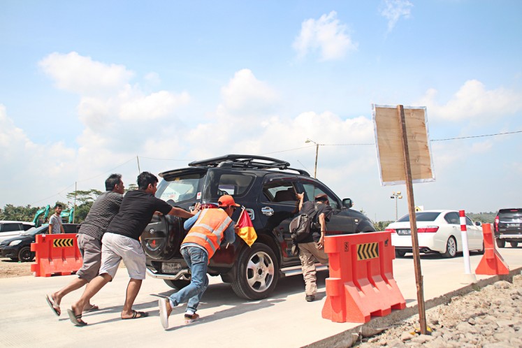 A stalled vehicle is pushed on the Salatiga-Kartasura functional toll road on June 11. 