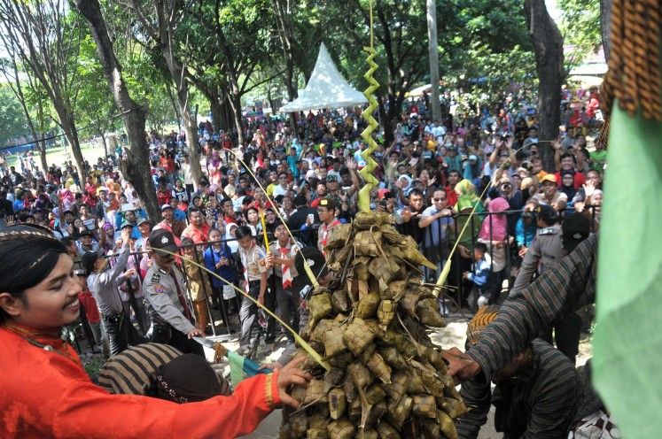 Thousands of people eagerly wait to receive 'ketupat' (rice cake) in the Grebeg Syawal ritual at Solo Zoo, Surakarta, Central Java. 