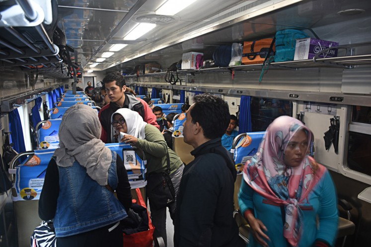Long journey: Passengers put their belongings in overhead baggage storage areas onboard a train that will depart to Jakarta from Kota Baru Station in Malang, East Java, on June 21. 