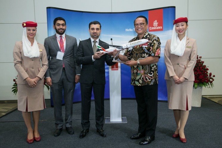 Emirates country manager for Indonesia Rashid Al Ardha (second left), Emirates senior vice president of Far East commercial operations Badr Abbas (third left) and the tourism minister's senior adviser on air accessibility, Robert Daniel Waloni (second right), pose for a photograph with Emirates stewardesses.