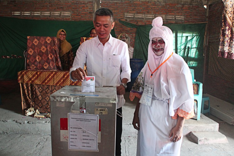 Enthusiastic: General Elections Commission member Wahyu Setiawan casts his vote at a ghost-themed polling station in Randusari subdistrict, South Semarang district, Semarang city, Central Java, on June 27. 
