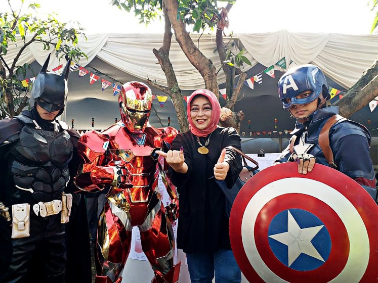 Show your creativity: A voter takes a picture with election officials wearing costumes of Superheroes at polling station TPS 3 in Citarum subdistrict, Bandung, West Java, after casting vote for the West Java gubernatorial election on June 27. 