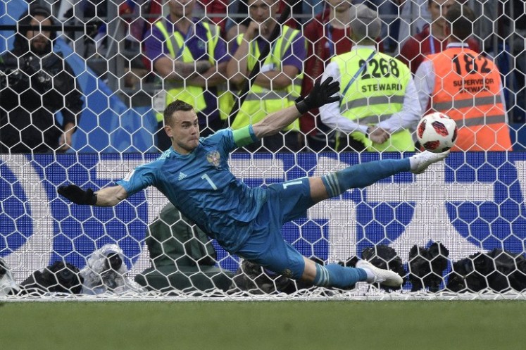 Russia's goalkeeper Igor Akinfeev stops a shot by Spain's forward Iago Aspas during the penalty shootout of the Russia 2018 World Cup round of 16 football match between Spain and Russia at the Luzhniki Stadium in Moscow on July 1, 2018. 